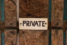 A Sign That Says PRIVATE On The Background Of A Wooden Board. Old Private Sign