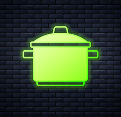 Sticker - Glowing neon Cooking pot icon isolated on brick wall background. Boil or stew food symbol. Vector