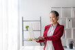 © amnaj - Asian senior female executive with laptop computer working in office.