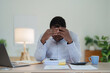 © Jirapong - Burnout American African business man in stress works with many paperwork document, migraine attack, Freelance, work from home