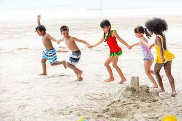 Wall Mural - Group of Diversity little child boy and girl friends running and playing sea water at tropical beach together on summer vacation. Happy children kids enjoy and fun outdoor lifestyle on beach holiday.