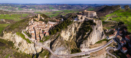 Wall Mural - Unique beautiful places of Italy. Emilia Romagna region. Aerial drone view of impressive San Leo medieval castle located in the top of sandstone rock and village