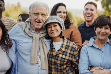 Group of multi generational people having fun together at city park while smiling on camera