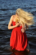 © beerfan - beautiful expressive woman in red dress standing in the water, concept