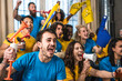 © Davide Zanin - Multiracial joyful sport fans watching game on TV at home - Supporters having fun on sofa for competition event on TV - Friends celebrating victory when sport team wins worlds championship