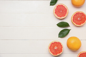 Wall Mural - Composition with ripe grapefruit and plant leaves on light wooden background