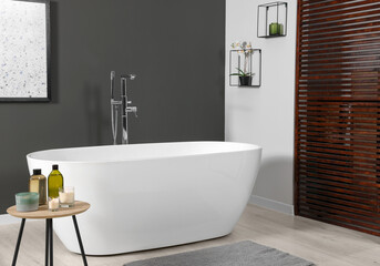 Wall Mural - Stylish bathroom interior with ceramic tub and care products on coffee table