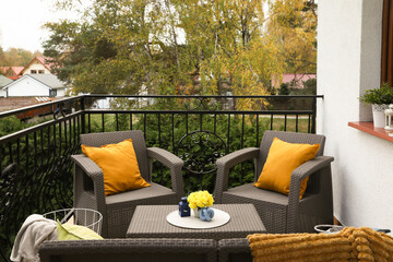 Canvas Print - Colorful pillows, soft blanket and yellow chrysanthemum flowers on rattan garden furniture outdoors