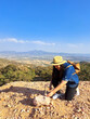 Latina woman with hat and miner's pick hammer works as a geologist, studies the composition and structure of the mineral soil of the mountain
