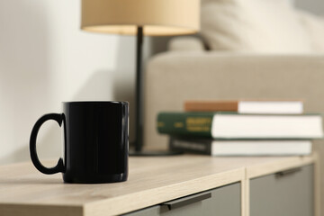 Wall Mural - Black mug on wooden table indoors. Mockup for design