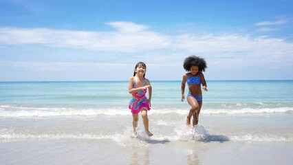 Wall Mural - Group of Diversity child girl friends running and playing sea water at tropical beach together on summer vacation. Happy children kids enjoy and fun outdoor lifestyle travel ocean on beach holiday.