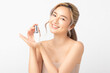 © Shutter B - Happy beautiful young asian woman holding cosmetic cream blank bottle, Fashion model, Health wellness, Beautiful girl skin care and facial treatment. Isolated on white background.