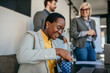© La Famiglia - The team celebrated a female colleague's birthday in the office during a meeting. Focus on a black businesswoman opening a gift