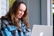 © Oleksandra - teenage girl with a laptop sitting on the porch of house. She watching the news doing homework online conference backpack folder water bottle pencil ordinary people real life