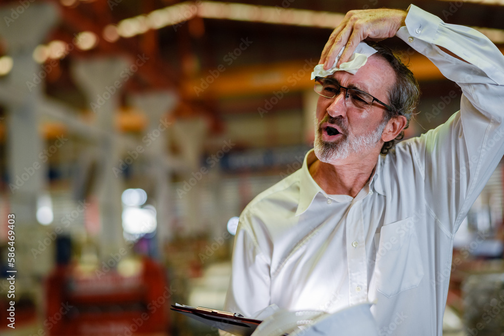 boss manager engineer with helmet tired in construction factory heavy industry . tired senior worker taking break and use tissue paper wiping sweat from forehead heat wave high temperature.