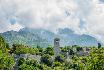 Bar is a touristic and historical town with clock tower and white clouds on blue sky located on the coast of the Adriatic Sea and also the main port of Montenegro 