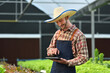 © Prathankarnpap - Smiling farmer analyzing farming data on digital tablet at greenhouse. Innovation technology for smart farm system concept