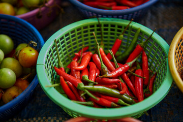 Wall Mural - Red and green chili peppers in basket for sale at market