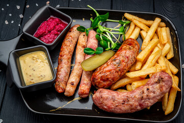 Wall Mural - Different sausages in a pan with fried potatoes