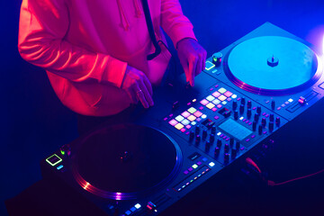 Wall Mural - Hands of a DJ creating and regulating music on dj console mixer at club concert