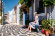 Woman in long dress sitting on bench in greek village Koskinou in Rhodes island in Greece