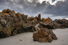 Rocky Outcrops On The Beach Beneath Storm Clouds