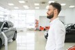 © Serhii - Man confident customer male buyer client wear white shirt choose auto want buy new automobile in showroom vehicle dealership store motor show indoor Sales concept.