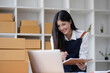 © wichayada - Startup small business entrepreneur SME, asian woman packing cloth in box. Portrait young Asian small business owner home office, online sell marketing delivery, SME e-commerce telemarketing concept.