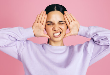 Wall Mural - Fun and funny faces: Woman makes a funny expression in a studio