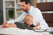 © standret - With stethoscope. Doctor with little baby is working in the cabinet
