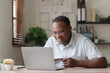 © itchaznong - Young african american man using laptop hold credit bank card. banking application, online shopping concept
