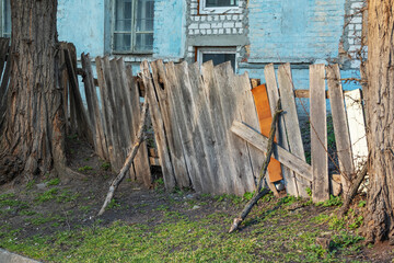 Old wooden fence near the house close-up on a sunny day