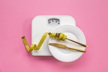 Wall Mural - Weight scale and tape measure over dinner fork and knife on the plate