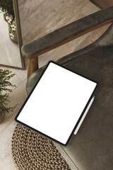 Lifestyle editable mockup of new version tablet in trendy thin frame design with white empty screen in cozy interior for showing own social media designs and arts 