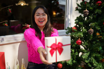 Wall Mural - Happy excited asian woman hands holding Christmas gift box. cheerful girl packing Xmas present or open box xmas new year birthday gift.