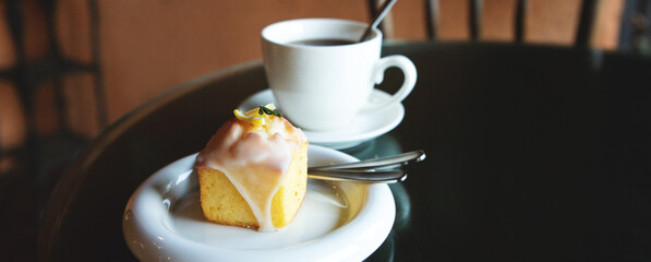 Wall Mural - lemon cake and a cup of tea on a table in a cafe