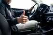 Happy driver in car, thumbs up. Man driving. Smiling positive new vehicle buyer and owner. Good customer service in taxi, dealership, insurance, inspection or maintenance business. Success in repair.