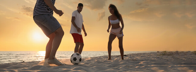 Poster - Group of friends playing football on sandy beach, low angle view. Banner design