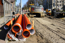Street Reconstruction Site, Stacked Plastic Sewage Pipes, Vertical Well, Excavator, Dewatering Pump