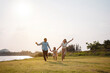 © Kiattisak - Happy family in the park sunset light. family on weekend running together in the meadow with river Parents hold the child hands.health life insurance plan concept.