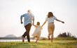 © Kiattisak - Happy family in the park sunset light. family on weekend running together in the meadow with river Parents hold the child hands.health life insurance plan concept.