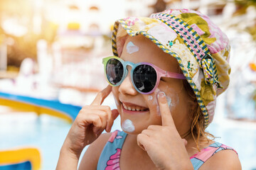child put on sunscreen on face. skin protection from sunburn