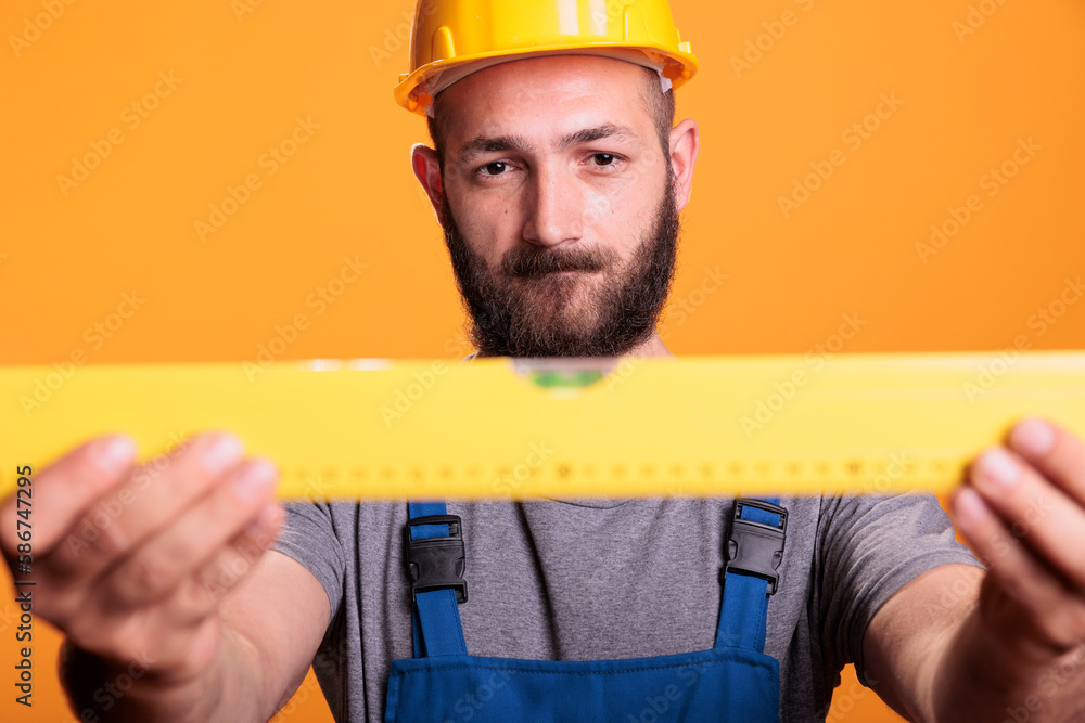 Confident Ruler Confident male carpenter looking at construction leveler before working ...