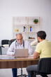 © Elnur - Young male patient visiting old male doctor