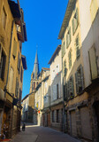 Fototapeta Uliczki - Narrow street of Aurillac, southern France. Rows of old-fashioned houses along paved walkway.