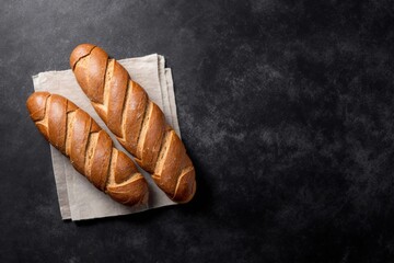 bread on a table, two freshly baked loaves, freshly baked bread on top of a tea towel on a black stone table