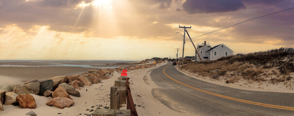 Wall Mural - Sunlight through the storm clouds over roadway along Chapin Beach