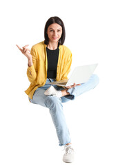 Pretty young woman with laptop sitting on chair against white background