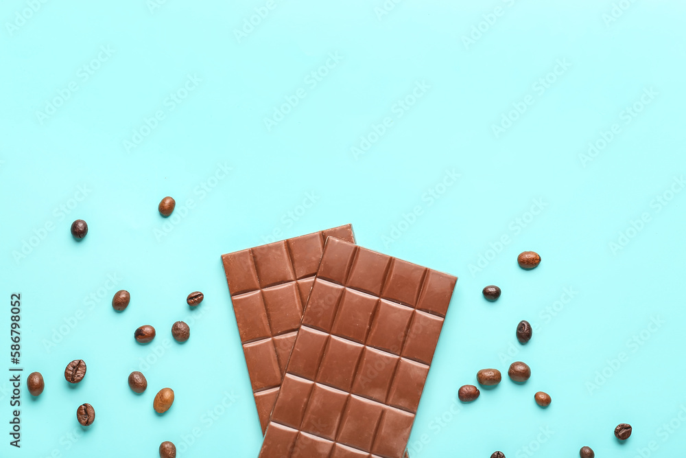 Tasty chocolate bars and coffee beans on color background