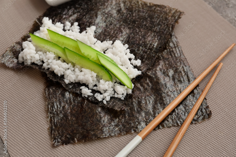 Nori and ingredients for preparing sushi rolls on table